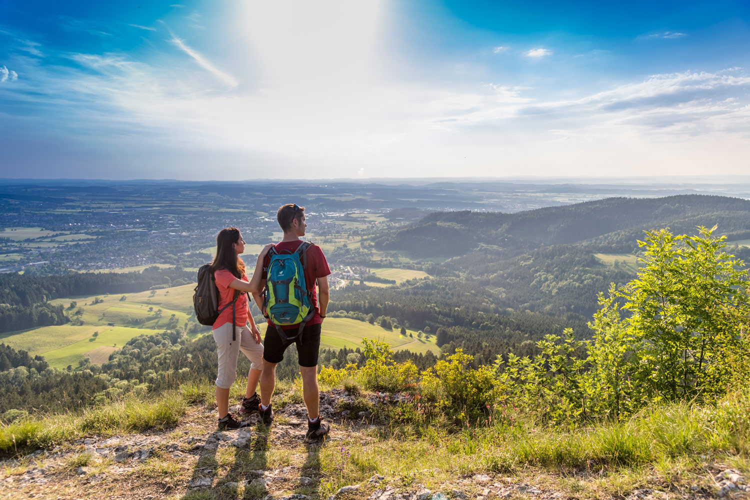 Zwei Wanderbegeisterte genießen die Fernsicht von einem Aussichtspunkt in Baden-Württemberg.